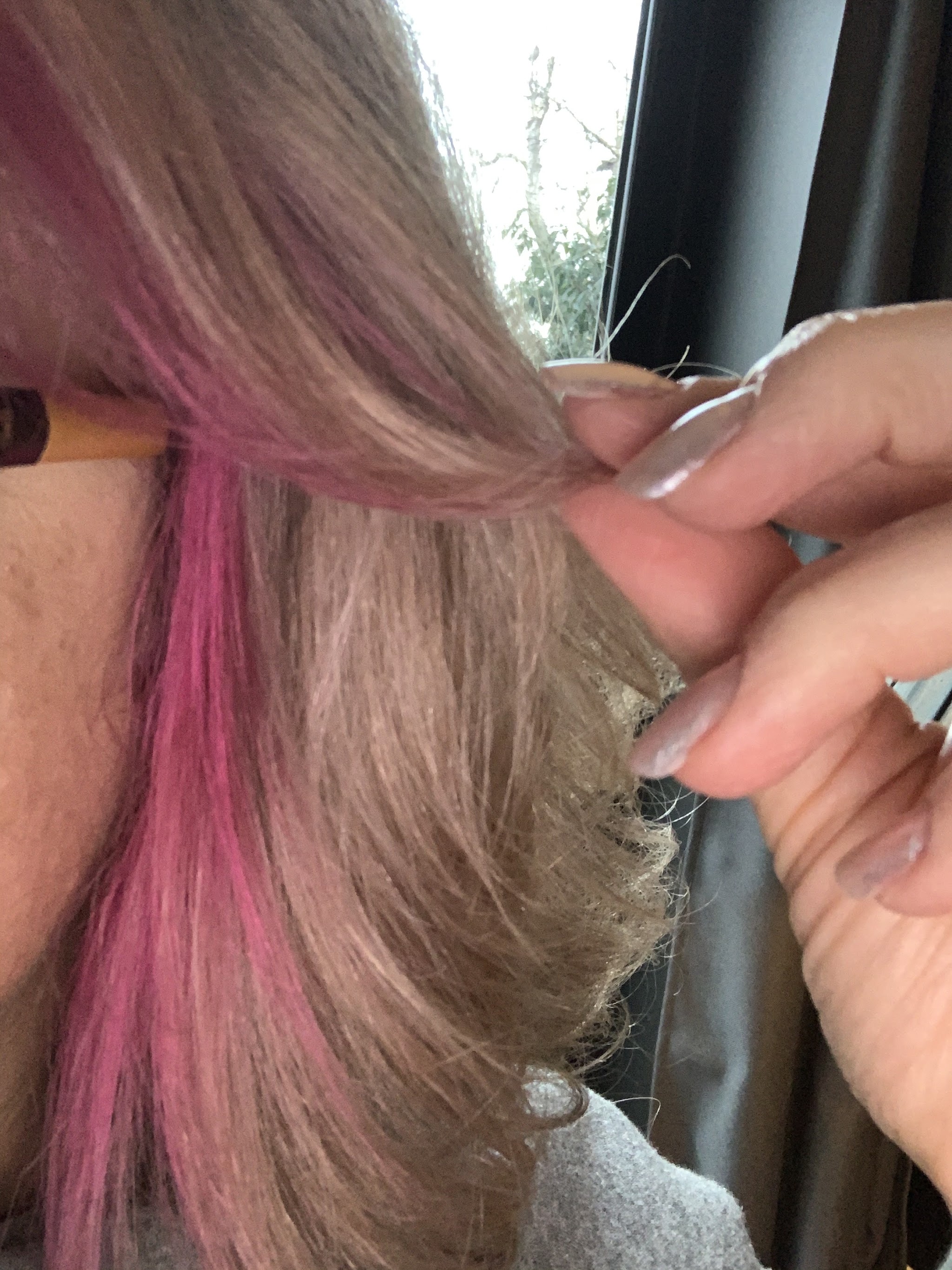 A pink colour streak through light brown hair